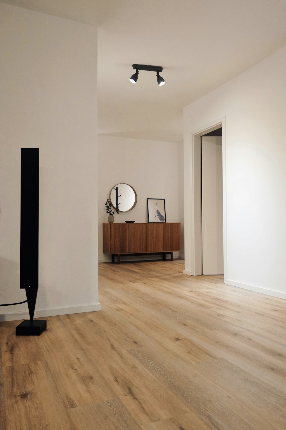 Interior despejado con piso de tablones de madera y paredes blancas.